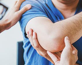 Doctor consulting with patient. Elbow muscule pain problems.